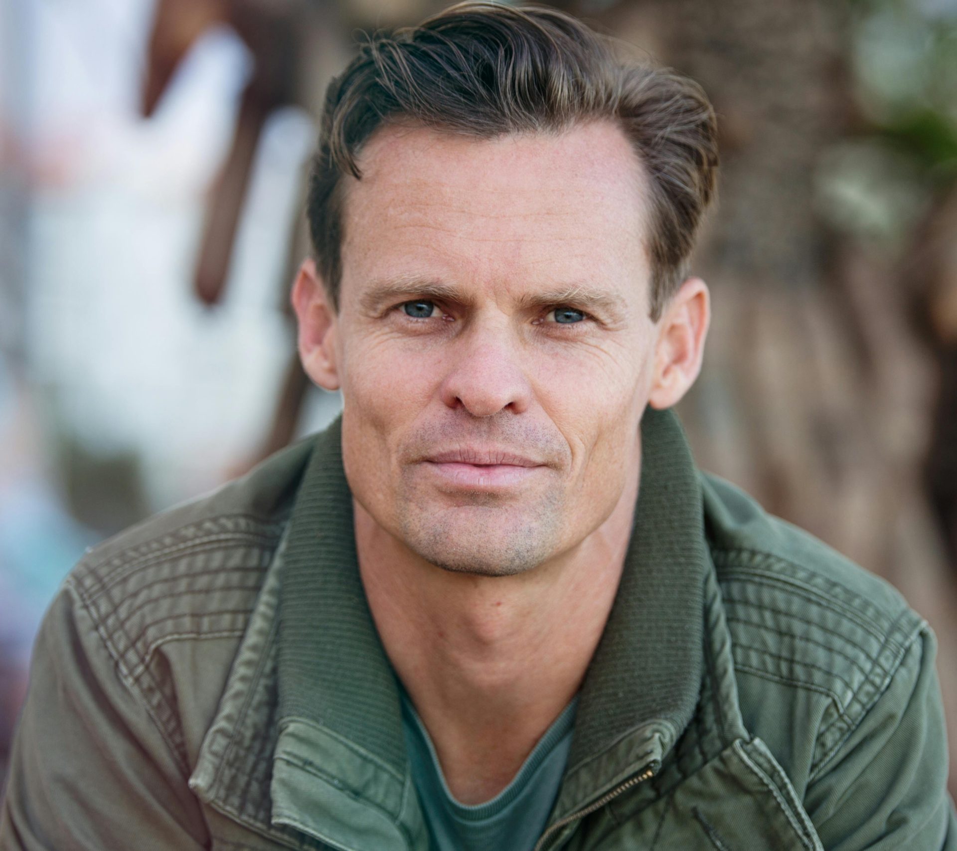Close-up portrait of a man wearing a casual jacket outdoors.